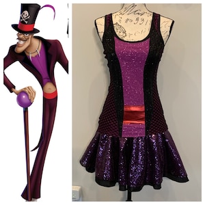 Könnte beinhalten: Ein lila-schwarzes Paillettenkleid mit roter Schärpe. Das Kleid hat ein schwarzes Netz-Oberteil und einen lila Rock mit gerafftem Saum. Das Kleid befindet sich auf einer Puppe.