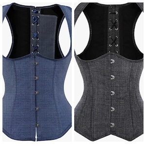 May include: Two denim corsets with a black lining. One corset is blue and the other is gray. Both corsets have a lace-up back and a button-up front.