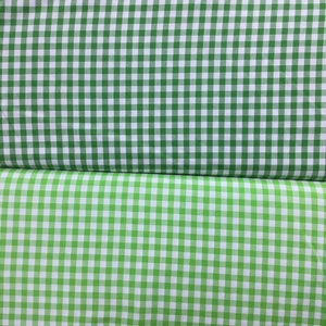 May include: Two pieces of green and white gingham fabric. The top piece is a darker green and the bottom piece is a lighter green.