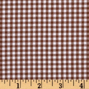 May include: Brown and white gingham fabric with a 1 inch grid pattern. The fabric is measured with a ruler in inches.