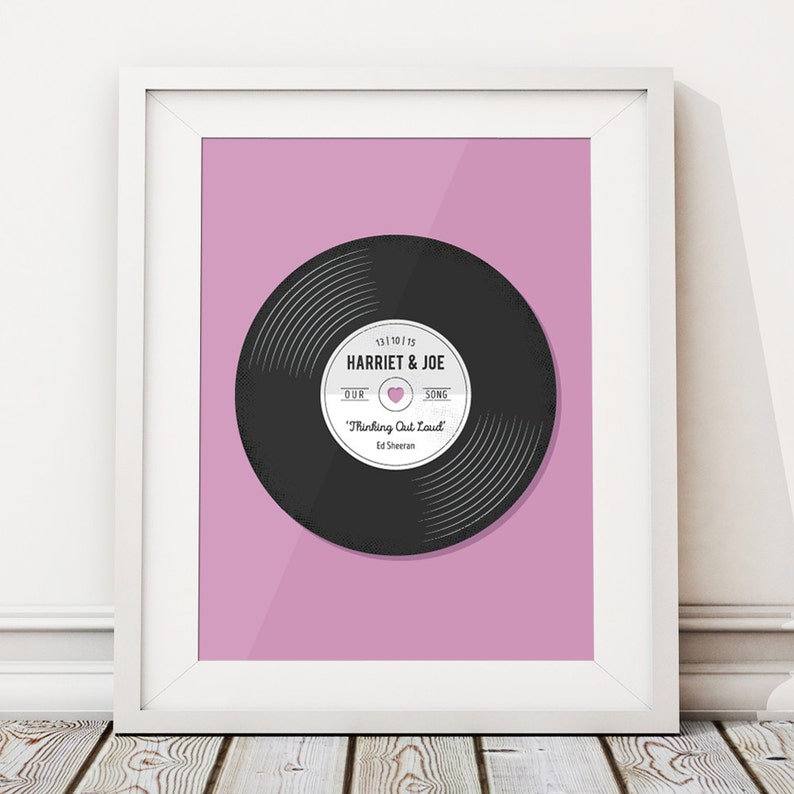 Op de afbeelding: Een roze achtergrond met een zwarte vinylplaat. Het platenlabel zegt "13.10.15 HARRIET & JOE ONZE SONG "Thinking Out Loud" Ed Sheeran".