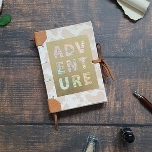 Handmade travel journal, A6. Map cover with the word ADVENTURE on the front. Leather details. Blank pages.