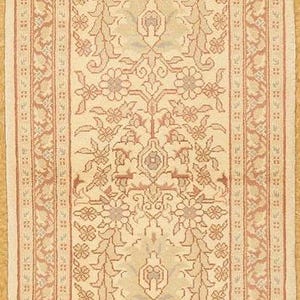 May include: Cream-colored rectangular rug with a detailed floral pattern in shades of peach and brown. The rug has a border with repeating floral and geometric designs, suitable for home decor.