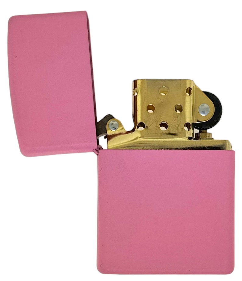 May include: A pink lighter with a gold hinge and a gold top. The lighter is open and the lid is flipped back.