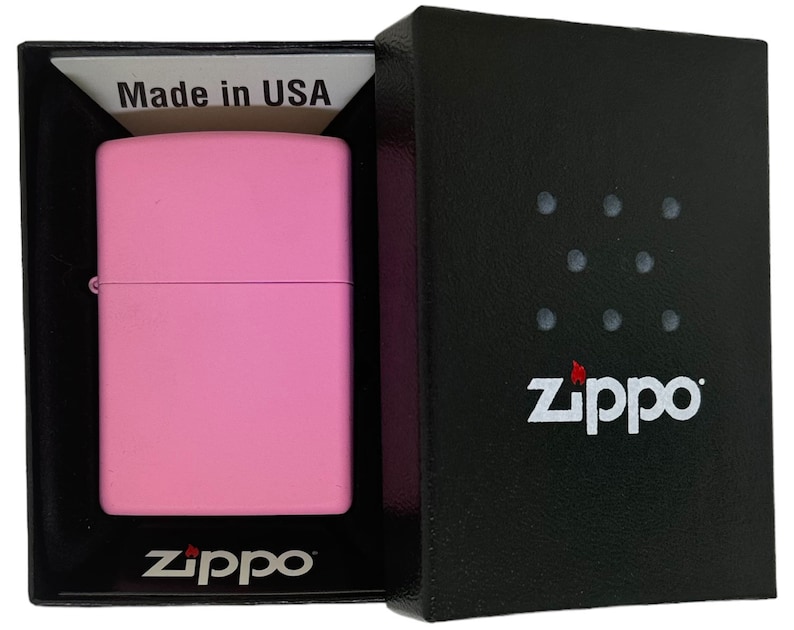 May include: A pink Zippo lighter in a black box with the Zippo logo and the words "Made in USA".