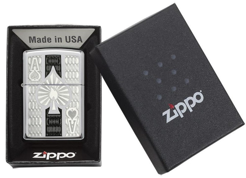 Pu&ograve; includere: Un accendino Zippo argentato con un design in bianco e nero che presenta l'Asso di Picche. L'accendino &egrave; nella sua scatola originale, che &egrave; nera con il logo Zippo.