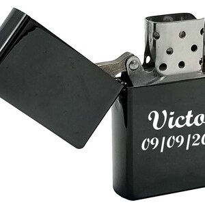May include: Black lighter with a silver top and a personalized inscription that reads "Victor 09/09/2020".