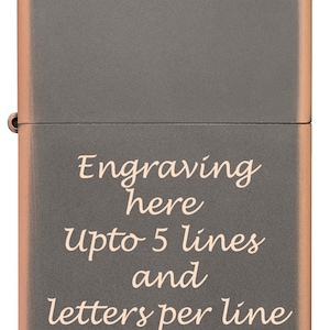 May include: A gray metal lighter with a copper trim. The lighter has an engraved message that reads "Engraving here upto 5 lines and letters per line".