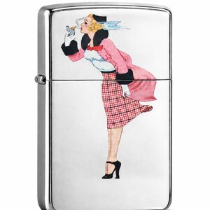 May include: A silver-colored, rectangular lighter with a painted illustration of a woman in a pink coat and plaid skirt. The woman is smoking a cigarette. The lighter has a hinged lid and a side wheel.