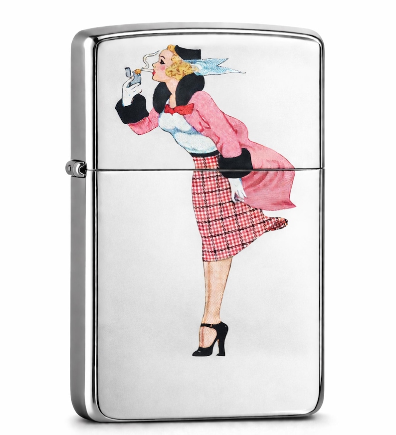May include: A silver-colored, rectangular lighter with a painted illustration of a woman in a pink coat and plaid skirt. The woman is smoking a cigarette. The lighter has a hinged lid and a side wheel.