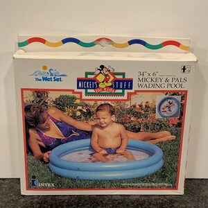May include: A white cardboard box for a Mickey & Pals wading pool by Intex. The box features the text The Wet Set, Mickey's Stuff for kids, and 34 inches by 6 inches. It displays a blue inflatable pool with a child sitting inside.