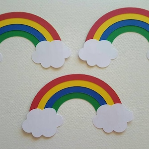 May include: Three paper rainbows with white clouds, each rainbow has red, yellow, blue, and green stripes.
