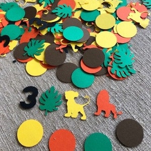 K&ouml;nnte beinhalten: Eine Sammlung bunter Papierkonfetti mit Dschungeltieren, Bl&auml;ttern und Kreisen in Gr&uuml;n-, Gelb-, Braun-, Orange- und Schwarzt&ouml;nen. Das Konfetti ist perfekt f&uuml;r eine Geburtstagsfeier oder andere Feierlichkeiten.