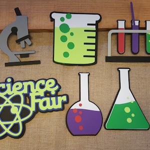 May include: Science Fair decorations with a microscope, beakers, test tubes, and an atom symbol. The decorations are made of colorful paper and are perfect for a science-themed party or classroom.