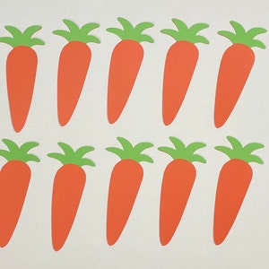 May include: Ten orange paper carrots with green tops. The carrots are cut out and ready to be used for crafts or decorations.