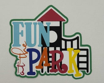 May include: A colorful die-cut design with the words "FUN PARK" in large, playful letters. The letters are in various colors, including blue, orange, and yellow, and are set against a white background with a green border. A red roof and black structure are also included.