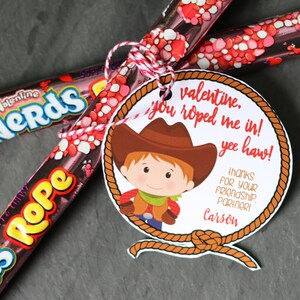 Pode incluir: Uma etiqueta de presente para o Dia dos Namorados com um desenho animado de um cowboy e o texto "valentine, you roped me in! yee haw! thanks for your friendship partner! Carson"