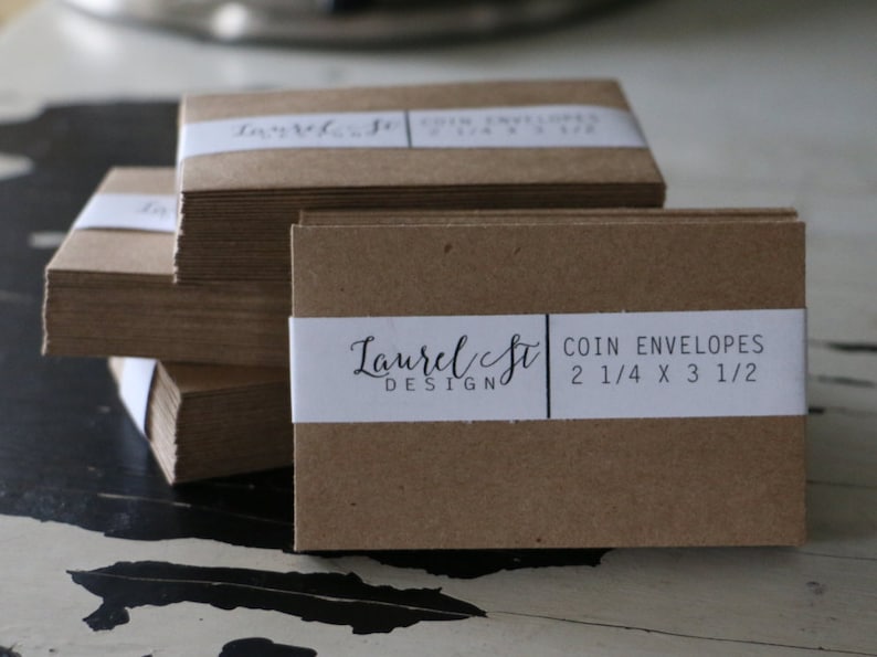 May include: A stack of brown coin envelopes with a white label that reads "Laurel & Co. Design COIN ENVELOPES 2 1/4 x 3 1/2"