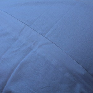 May include: A plain white pillowcase with a smooth, wrinkle-free surface.