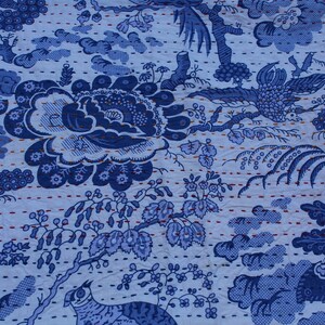 May include: Blue and white kantha quilt fabric with a floral and bird pattern. The fabric is quilted with a running stitch in a light blue thread.