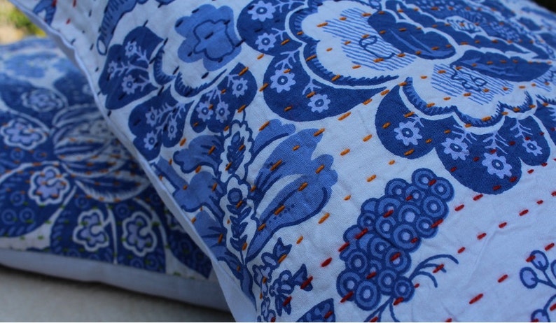 May include: Two blue and white patterned throw pillows with intricate embroidery. The pillows are made of a soft cotton fabric and feature a floral design.