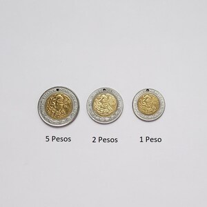 K&ouml;nnte beinhalten: Drei runde M&uuml;nzanh&auml;nger mit goldfarbener Mitte und silberfarbenem Au&szlig;enring, jeweils mit einem kleinen Loch an der Oberseite. Die M&uuml;nzen sind mit 5 Pesos, 2 Pesos und 1 Peso beschriftet und zeigen das mexikanische Wappen.