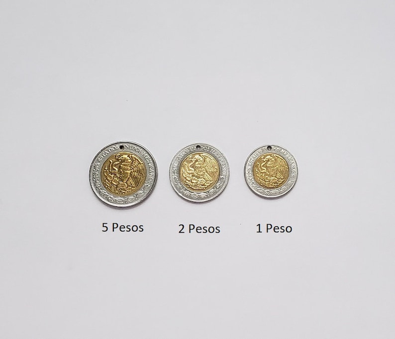 K&ouml;nnte beinhalten: Drei runde M&uuml;nzanh&auml;nger mit goldfarbener Mitte und silberfarbenem Au&szlig;enring, jeweils mit einem kleinen Loch an der Oberseite. Die M&uuml;nzen sind mit 5 Pesos, 2 Pesos und 1 Peso beschriftet und zeigen das mexikanische Wappen.