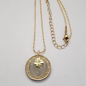 May include: A gold chain necklace with a two-euro coin pendant featuring a four-leaf clover charm.