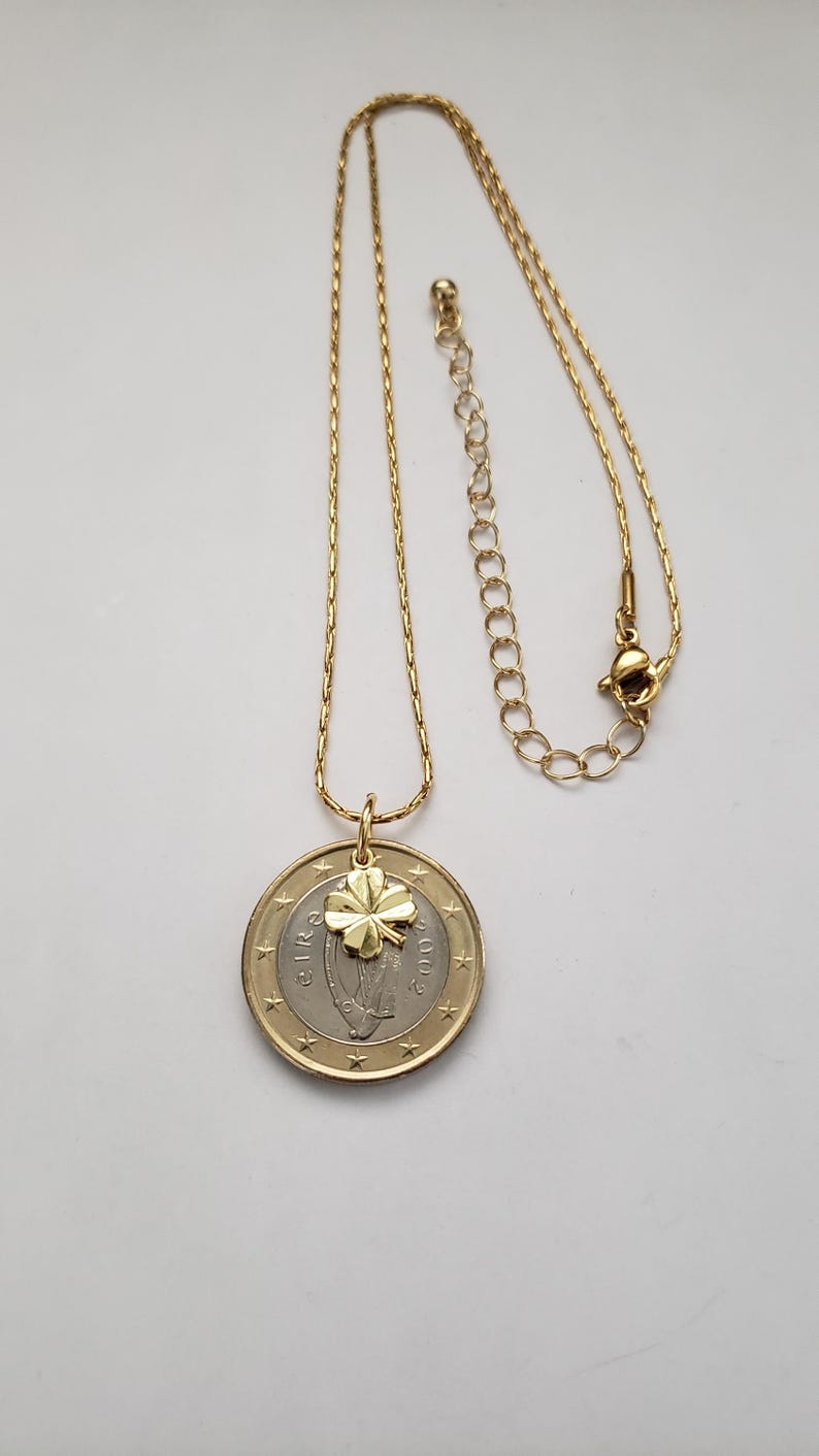 May include: A gold chain necklace with a two-euro coin pendant featuring a four-leaf clover charm.