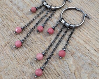 May include: A pair of silver hoop earrings with dangling chains and pink gemstone beads.