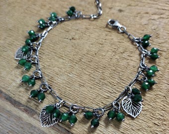 May include: A silver chain bracelet with green gemstone beads and silver leaf charms.