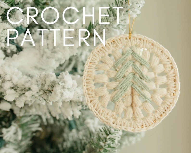 Puede incluir: Un adorno navide&ntilde;o de crochet en forma de &aacute;rbol, con fondo blanco y detalles verdes. El adorno est&aacute; colgado de una rama de &aacute;rbol de Navidad cubierta de nieve. El texto "CROCHET PATTERN" es visible en la imagen.