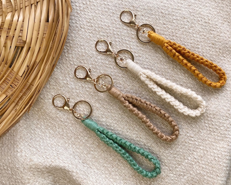 May include: Four keychains with gold key rings and braided cords in green, beige, white, and yellow.