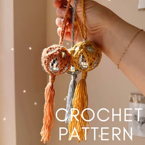 Könnte beinhalten: Drei gehäkelte Discokugel-Anhänger mit Quasten. Die Anhänger sind in Orange-, Gelb- und Grautönen gehalten.  CROCHET PATTERN steht in weißer Schrift auf braunem Hintergrund.