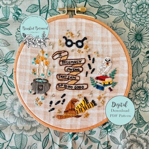 Può includere: Arte di ricamo a cerchio con tema di Harry Potter con una citazione dal libro: "Giuro solennemente che le mie intenzioni non sono buone." Il cerchio include anche un calderone, candele, occhiali, un gufo bianco, una pila di libri, un cappello e un paio di calzini a righe.