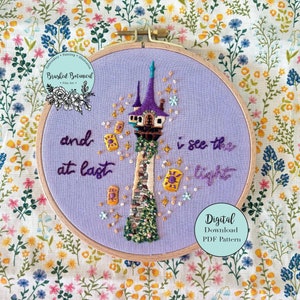 Peut inclure: Cerceau de broderie violet avec un motif de point de croix représentant la tour de Raiponce du film Disney Tangled. La tour est entourée d'étoiles et de lanternes. Le texte "and at last I see the light" est brodé en fil violet.