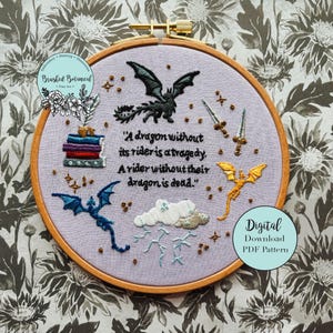 May include: Embroidered hoop art with a dragon theme. The design includes dragons, swords, books, and the quote "A dragon without its rider is a tragedy. A rider without their dragon is dead." The text "Digital Download PDF Pattern" is also included.