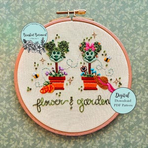 May include: Embroidered hoop art featuring two whimsical garden scenes with smiling faces, flowers, and bees. The text "flower & garden" is stitched below. The design includes the text "Digital Download PDF Pattern" and the logo "Brushed Botanical - Fine Art".