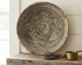 Peut inclure: Un grand bol en céramique ronde et patinée présentant une surface texturée et tachetée dans des tons de brun, gris et vert sourd avec un motif de feuilles en relief. À côté du bol se trouvent un petit bouquet de lavande séchée et une tasse à mesurer en laiton.