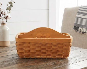 Peut inclure: Un panier rectangulaire tressé avec une finition brun clair, doté d'un séparateur central en bois avec une poignée découpée en forme de cœur. Le panier possède une base structurée et des côtés faits de bandes entrelacées, offrant un rangement.