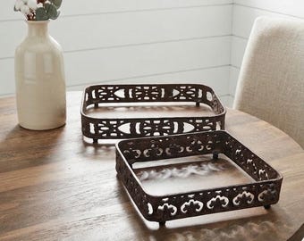Peut inclure: Deux plateaux rectangulaires en métal avec une finition brun foncé et un motif ajouré complexe sur les côtés. Chaque plateau présente de petits pieds surélevés aux coins, offrant un profil légèrement surélevé à ces objets décoratifs.