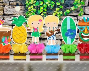 May include: Set of six luau themed centerpieces. Each centerpiece features a different Hawaiian themed character or object, including a pineapple, a coconut, a surfboard, a tiki idol, and two figures wearing leis. The centerpieces are displayed on small brown boxes with colorful tissue paper.