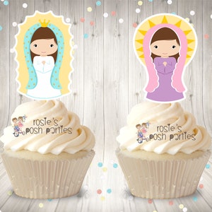May include: Two cupcakes with white frosting topped with images of the Virgin Mary. The image on the left cupcake is of the Virgin Mary wearing a blue robe and a gold crown. The image on the right cupcake is of the Virgin Mary wearing a purple robe and a pink crown. Both images have a yellow halo. The cupcakes are decorated with the text "rosie's posh parties".