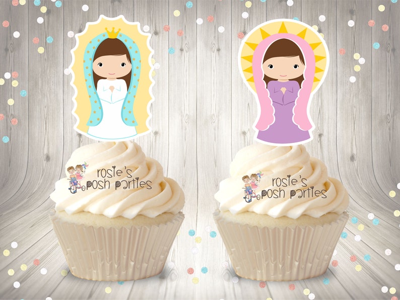 May include: Two cupcakes with white frosting topped with images of the Virgin Mary. The image on the left cupcake is of the Virgin Mary wearing a blue robe and a gold crown. The image on the right cupcake is of the Virgin Mary wearing a purple robe and a pink crown. Both images have a yellow halo. The cupcakes are decorated with the text "rosie's posh parties".