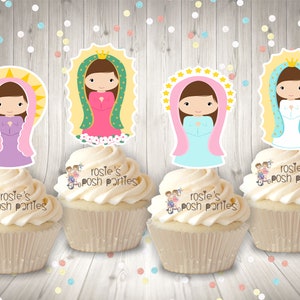 May include: Four cupcakes decorated with images of the Virgin Mary. Each cupcake has a different colored dress and halo. The cupcakes are topped with white frosting and the words "Rosie's Posh Parties" are written on the side.