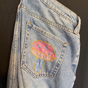 Calças jeans recicladas com remendos e bordados.