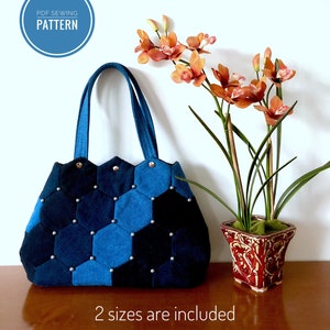 May include: A blue denim tote bag with silver studs, featuring a hexagonal pattern. The bag has two straps and is sitting on a wooden surface. The text "PDF SEWING PATTERN" is in a blue circle above the bag. The text "2 sizes are included" is below the bag.