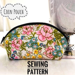 May include: A sewing pattern for a floral coin pouch. The pouch is white with pink, blue, and yellow flowers. The pouch has a black zipper and a black trim. The text "COIN POUCH" is in a speech bubble above the pouch. The text "SEWING PATTERN" is below the pouch.