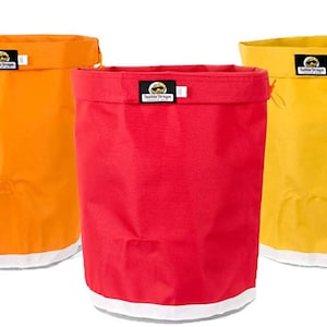 May include: Five colorful laundry bags with white drawstrings. The bags are purple, orange, red, yellow, and blue.