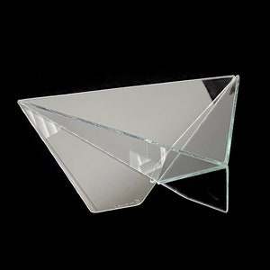 May include: A clear glass origami-style bowl with a reflective surface. The bowl is folded into a geometric shape, resembling a paper airplane.